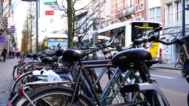 El autobús para en la carretera cerca de una gran cantidad de bicicletas en la acera — Vídeos de Stock