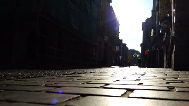 Helder vallen zonnestralen op het geplaveide straat — Stockvideo