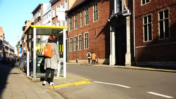 一个背着背包的女孩在停车场等着自行车的人 — 图库视频影像