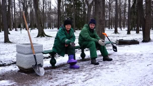 Arbeiter im Winterpark füttern die Vögel mit seinen Händen — Stockvideo