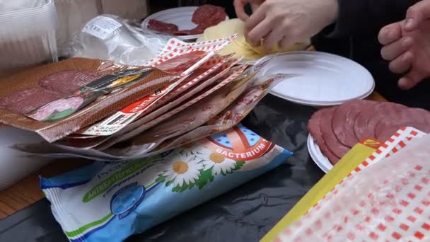 Petersburgo pessoas espalhadas em pratos descartáveis salsicha cortada e queijo — Vídeo de Stock