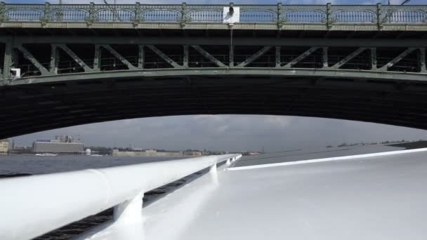 Ein Motorschiff fährt unter der Brücke der Brücke über die Newa — Stockvideo