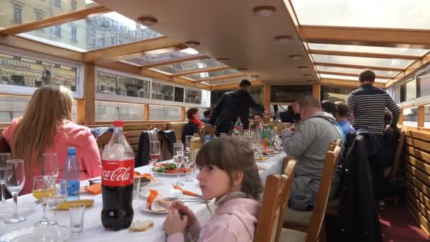 Op een schip zitten mensen aan een feestelijke tafel — Stockvideo