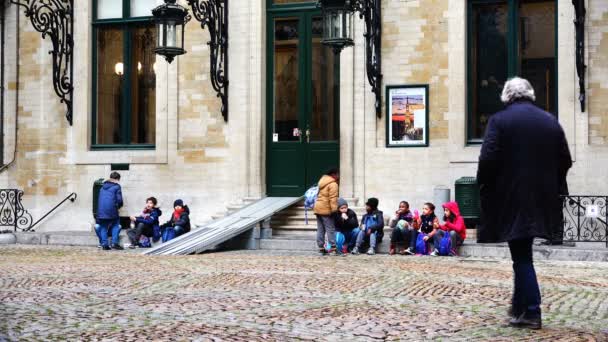 Dzieci w wieku szkolnym różnych narodów siedzą na kroki w pobliżu budynku — Wideo stockowe