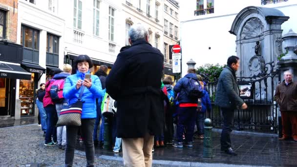 Tourists are photographed near the sculpture of the "Manneken Pis" — Stockvideo
