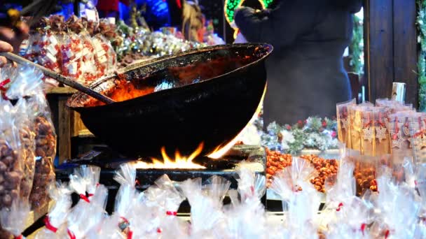 En kock kockar i gatan matlagning i en brand i en stor svart skål — Stockvideo