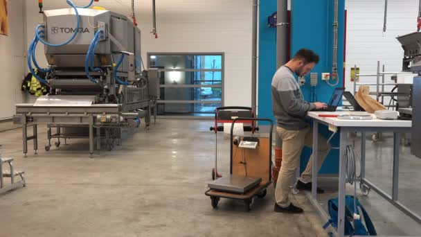 Programmeurs werken op de achtergrond van een machine voor het sorteren van amber — Stockvideo