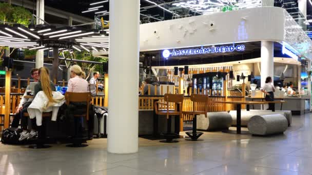 La gente está sentada en un café en el aeropuerto esperando su vuelo — Vídeos de Stock