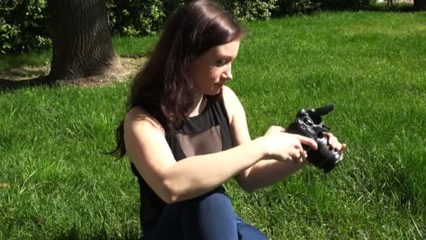 Een aantrekkelijke brunette past de Slr voor schietpartij — Stockvideo