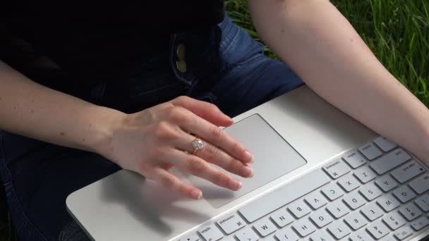 As mãos femininas movem um dedo no touchpad de computadores portáteis brancos — Vídeo de Stock