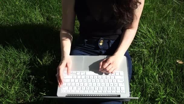 Una ragazza dalla pelle bianca con un seno grande lavora su un dispositivo di informazione portatile — Video Stock