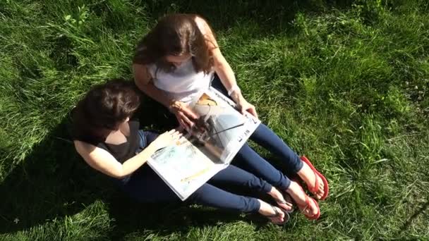 Meisjes op het gazon bekijken de historische boek van zeevarenden — Stockvideo