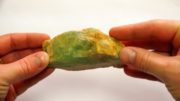 Un mineral verde con una superficie áspera de color naranja en un lado — Vídeos de Stock