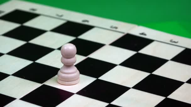 一个白色的棋子被一块棋盘上的一个黑色国王砍伤了 — 图库视频影像