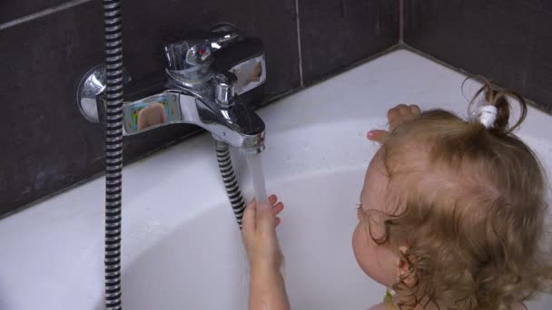 The child studies the operation of the mixer, opens and closes the tap — Stock Video