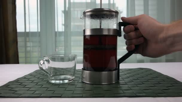 Mens hand pours tea into a transparent cup — Stock Video