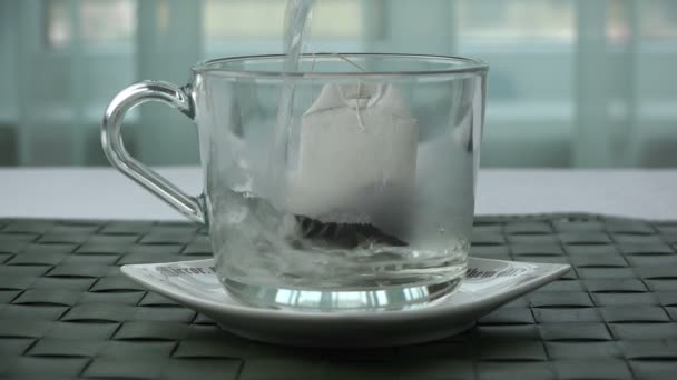 Vierta agua hirviendo sobre una bolsa de té en una taza — Vídeo de stock
