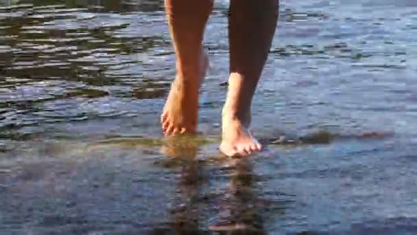 Het meisje is haar voeten in het water nat — Stockvideo