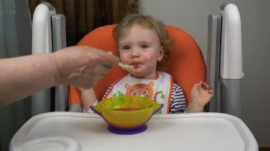 Büyükanne torunu büyük bir kaşık beslenir.