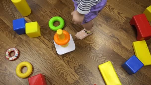 Bir çocuk çok renkli plastik oyuncaklar yere atar. — Stok video