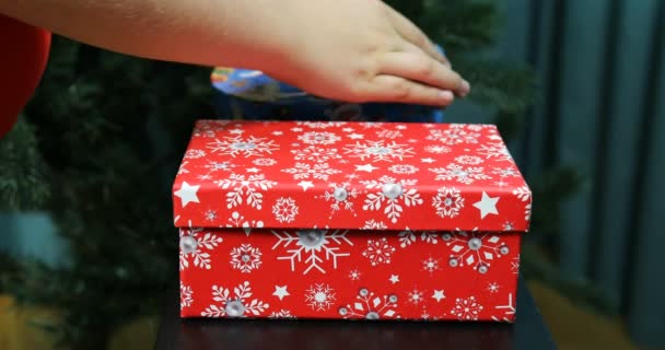 Childrens handen nemen kerstballen uit een feestelijke doos — Stockvideo