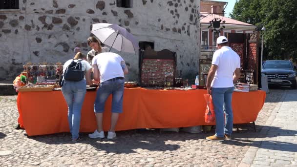 Туристы покупают сувениры в магазине на площади — стоковое видео