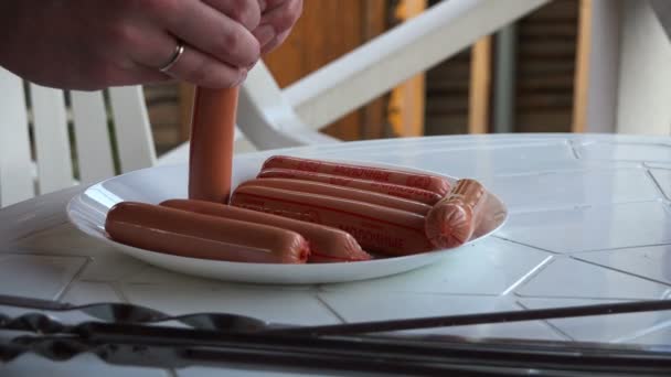 O cozinheiro remove a película protetora das salsichas — Vídeo de Stock