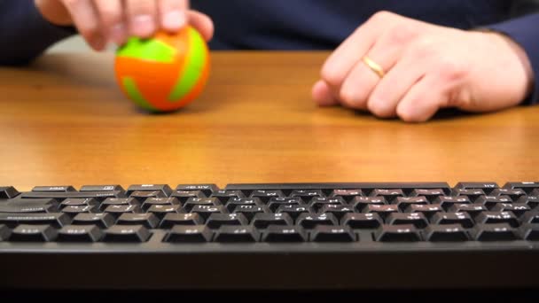 Mens mãos girar uma pequena bola ao lado do teclado — Vídeo de Stock