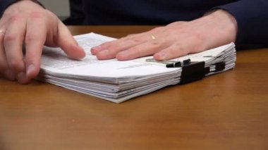 Katip s yün bir yığın belgelerin eller ve bir kalem masaya koy