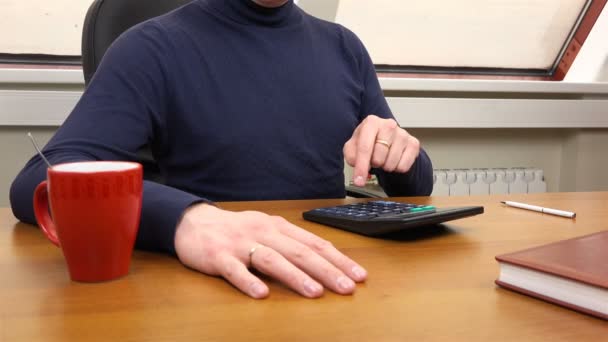 A man dials numbers on a calculator — Stock videók