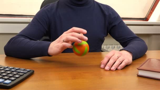 Ein Mann im Büro spielt auf einem Tisch mit einem Ball — Stockvideo