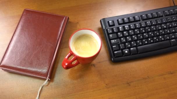 Die Tasse steht neben der Tastatur — Stockvideo