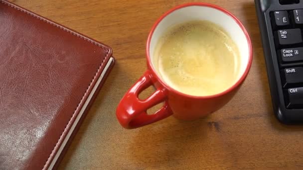 A red cup with coffee stands on the office desk — Stock Video