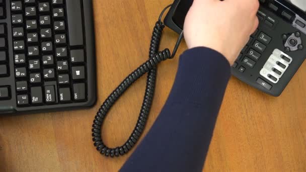 Hand plockar upp telefonen, sätter på tabellen och trycker på siffrorna — Stockvideo