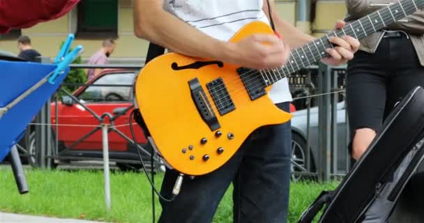 Un músico toca una guitarra amarilla de seis cuerdas — Vídeo de stock