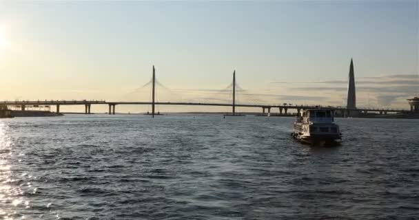 Motorová loď prochází podél řeky na pozadí visutý most — Stock video