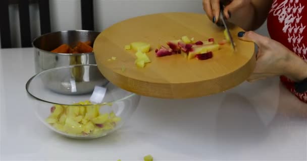 La jeune fille verse les pommes de terre tranchées dans un bol transparent — Video