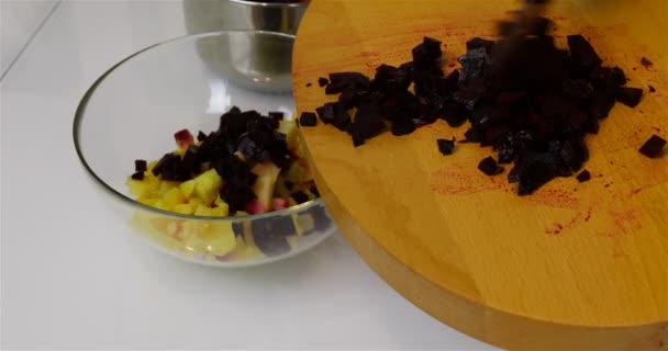 Нарезанная вареная свекла падает в миску с картошкой — стоковое видео