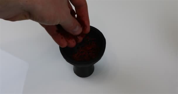 Заполнение и размещение табака в кальянной чашке — стоковое видео