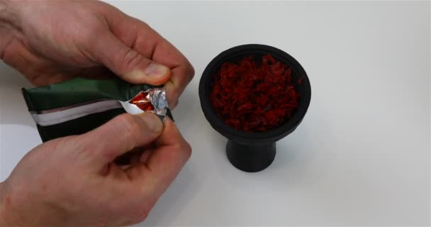 Adding tobacco to a hookah silicone cup — Stock Video