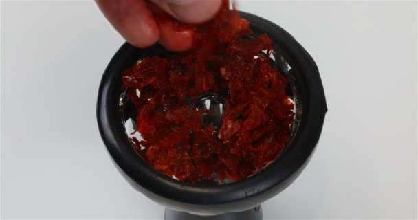 Курильщик кладет курильную смесь в стеклянную миску — стоковое видео