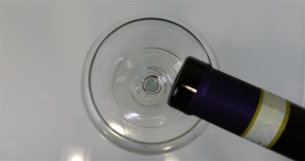 Красное вино наполняет стакан и прозрачный бокал вина — стоковое видео