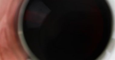 bir bardak kırmızı şarap masanın üstüne koy