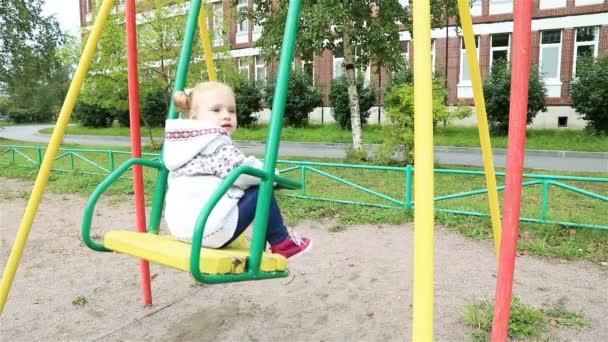 Дитина гойдається на гойдалках влітку — стокове відео