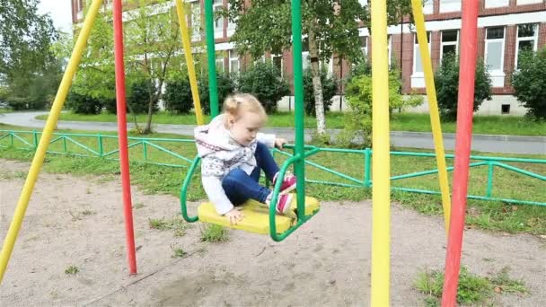 Le père offre sa main à la fille et l'aide à descendre des balançoires — Video