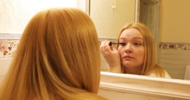 The blonde is putting mascara on in the bathroom — Stock Video