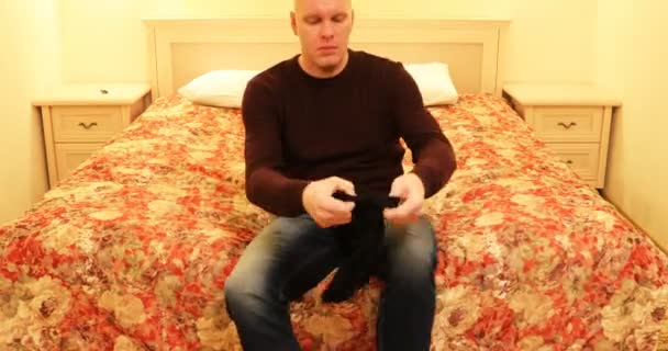 Il met des chaussettes noires sur ses jambes. — Video