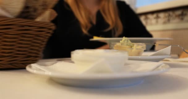 De gast van het café is het nemen van de kom met zure room en zet het in de soep met behulp van de lepel — Stockvideo