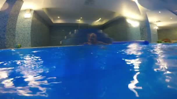 Liten flicka är scampering om i poolen — Stockvideo