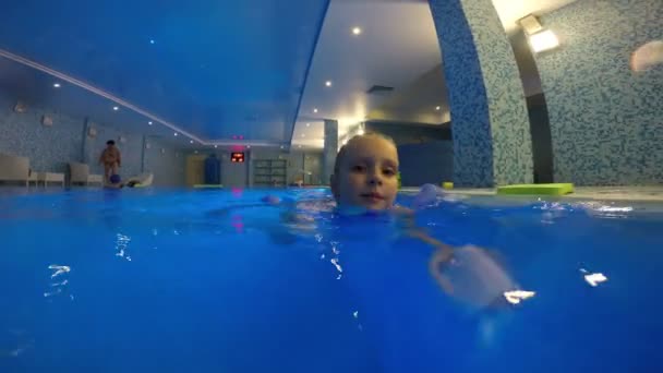 Маленькая девочка плавает в бассейне — стоковое видео